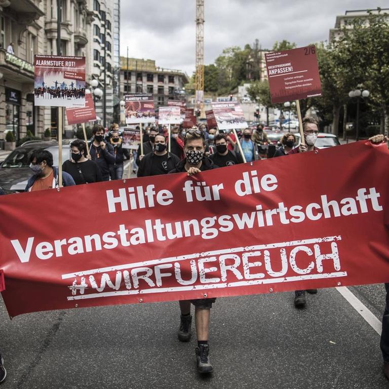 Demonstranten tragen ein Transparent mit der Aufschrift: "Hilfe für die Veranstaltungswirtschaft! #Wirfüreuch"