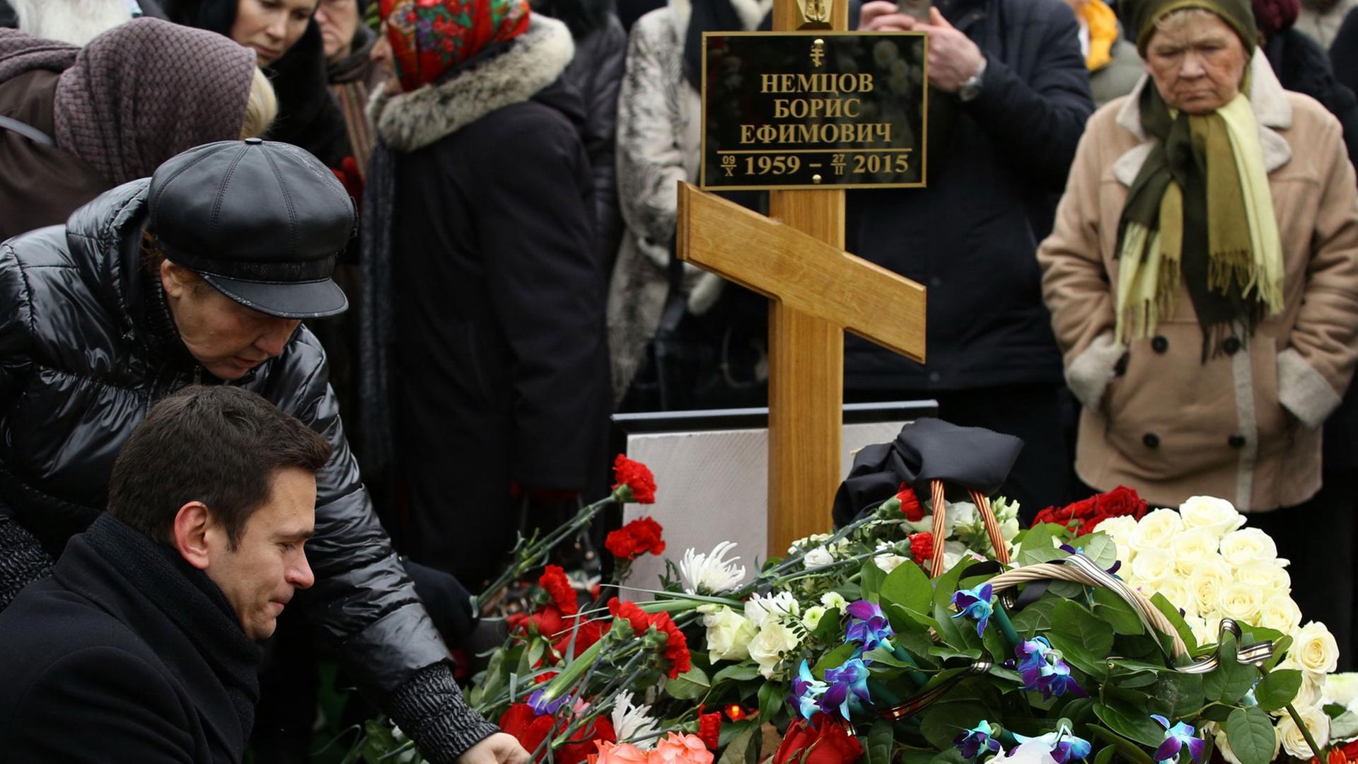Trauernde, darunter die Oppositionelle Ilya Yashin (l), legen Blumen auf das Grab von Kreml-Kritiker Boris Nemzow auf dem Trojekurowo-Friedhof in Moskau. Trauernde, darunter die Oppositionelle Ilya Yashin (l), legen Blumen auf das Grab von Kreml-Kritiker Boris Nemzow auf dem Trojekurowo-Friedhof in Moskau.