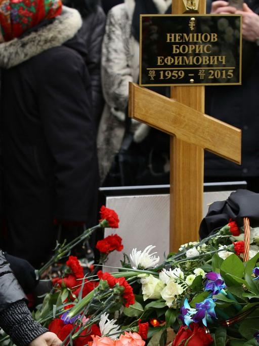 Trauernde, darunter die Oppositionelle Ilya Yashin (l), legen Blumen auf das Grab von Kreml-Kritiker Boris Nemzow auf dem Trojekurowo-Friedhof in Moskau.