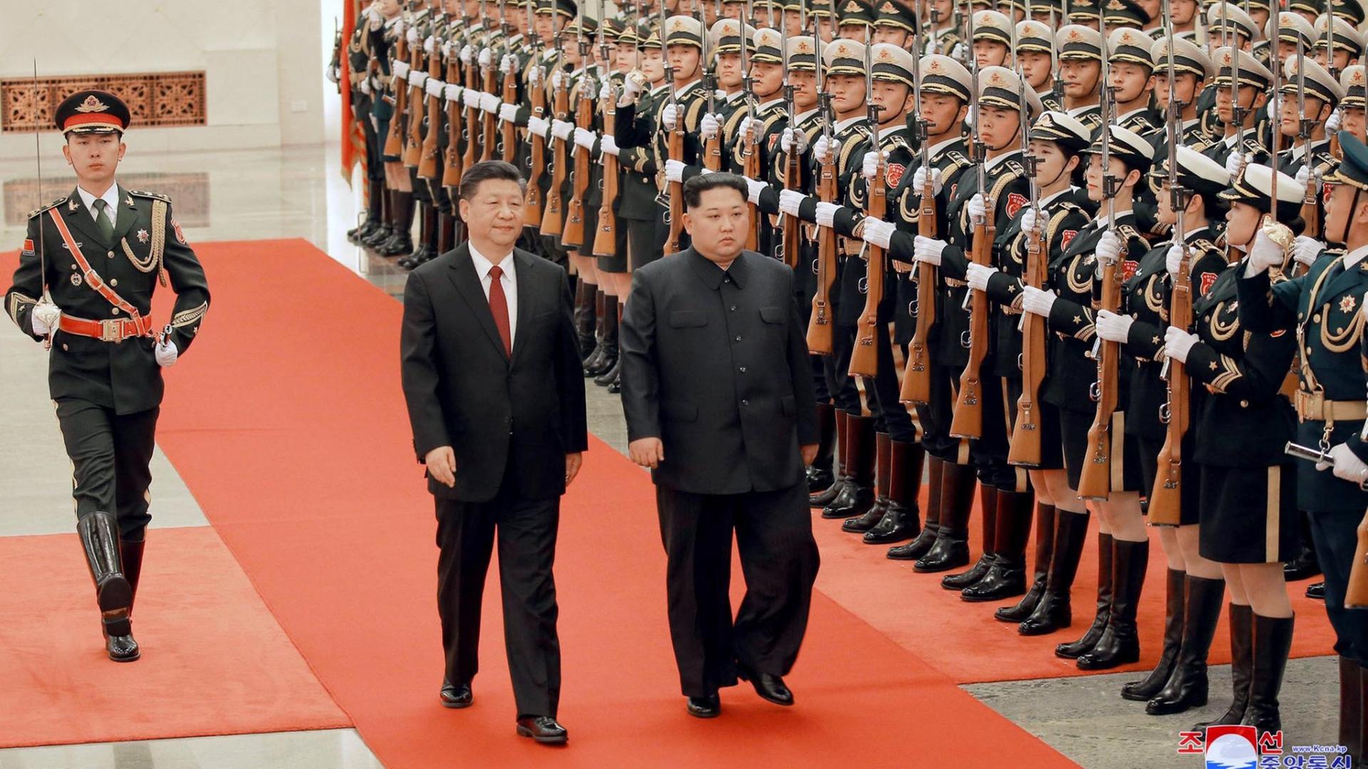 In this March 26, 2018, photo, North Korean leader Kim Jong Un, center right, and Chinese counterpart Xi Jinping, center left, inspect the honor guard at the Great Hall of the People in Beijing. North Korea's leader Kim and his Chinese counterpart Xi sought to portray strong ties between the long-time allies despite a recent chill as both countries on Wednesday, March 28, 2018, confirmed Kim's secret trip to Beijing this week. The content of this image is as provided and cannot be independently verified. Korean language watermark on image as provided by source reads: "KCNA" which is the abbreviation for Korean Central News Agency. (Korean Central News Agency/Korea News Service via AP)