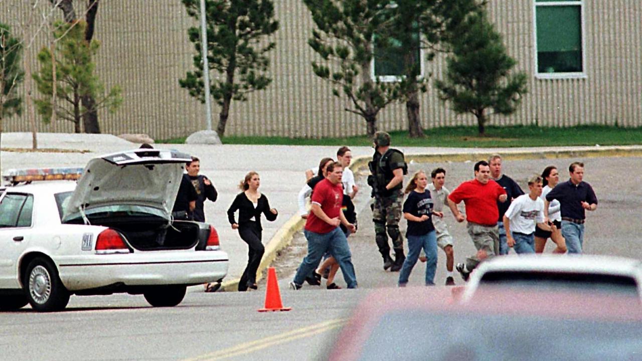 Von Polizisten geschützt rennen Schüler am 20.4.1999 in Littleton, Colorado aus der Columbine High School. 