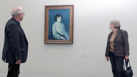 Zwei Besucher betrachten in der Ausstellung in der Pinakothek der Moderne in München das Gemälde "Madame Soler" (1903) von Pablo Picasso.