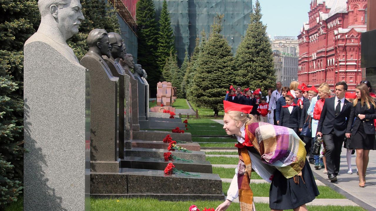 Eine Schülerin legt Blumen vor einer Stalin-Büste in Moskau ab.