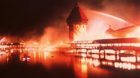 Blick auf die lichterloh brennende Brücke. Die 1333 erbaute älteste Holzbrücke Europas, die Kapellbrücke von Luzern, ist in der Nacht vom 17. zum 18. August 1993 durch einen Brand weitgehend zerstört worden