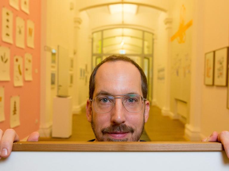 Der Zeichner und Illustrator Christoph Niemann hält am 19.01.2016 in Hamburg im Museum für Kunst und Gewerbe (MKG) eines seiner Aquarelle in den Händen. Niemanns Ausstellung "Unterm Strich" ist vom 20. Januar bis zum 10. April 2016 zu sehen.