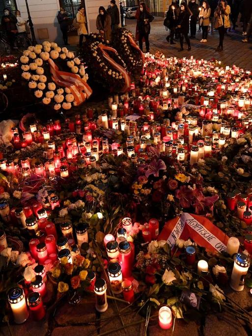 Menschen vor einem Kerzen- und Blumenmeer an einem der Tatorte im Bereich der Seitenstettengasse in der Wiener Innenstadt am Donnerstag, Österreich, 5. November 2020.