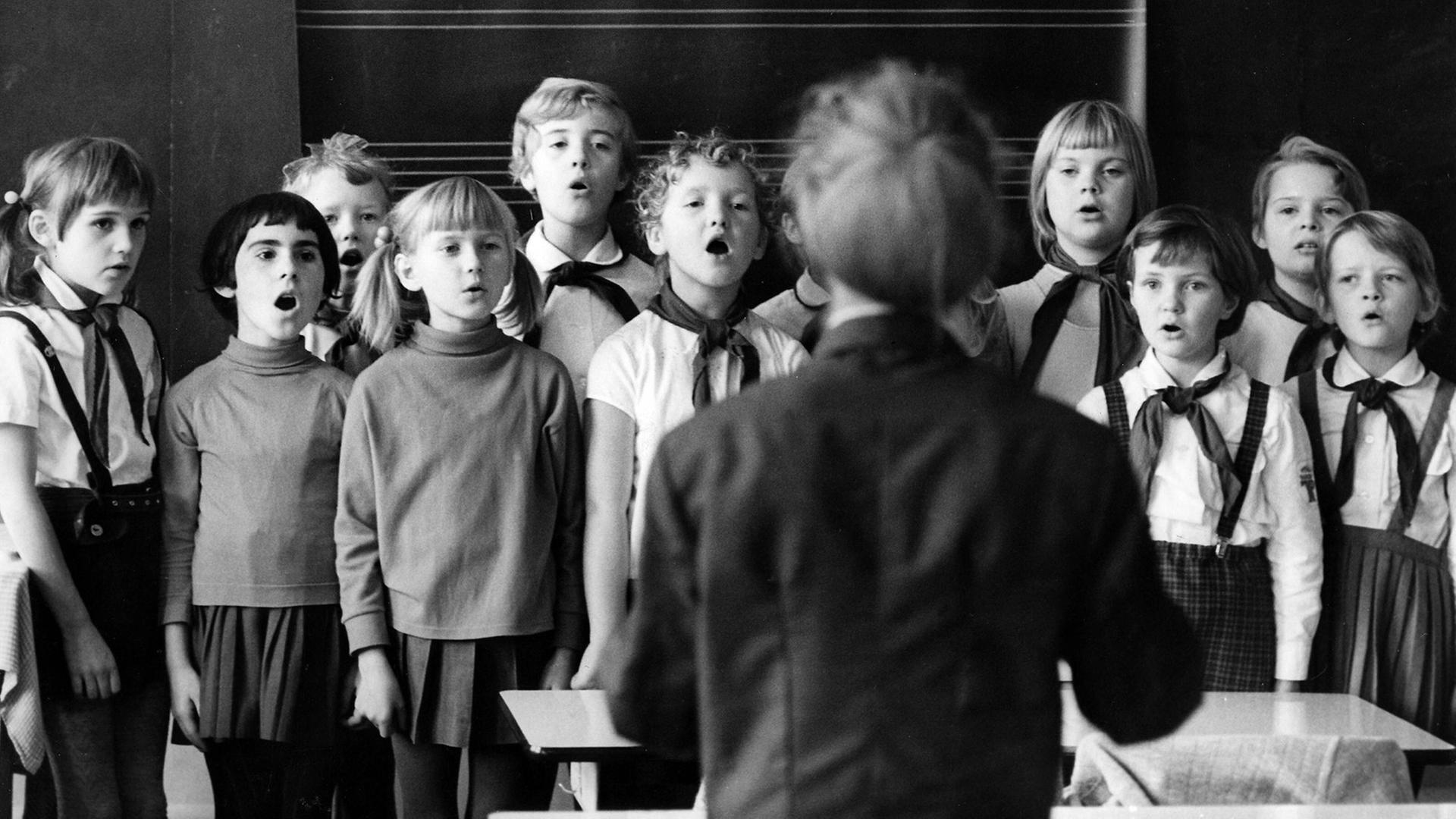 Schulalltg in Dresden, 1970: Pioniere und Lehrerin singen ein Lied zum Start in den Unterrichtstag.