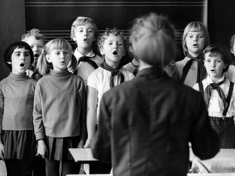 Schulalltg in Dresden, 1970: Pioniere und Lehrerin singen ein Lied zum Start in den Unterrichtstag.