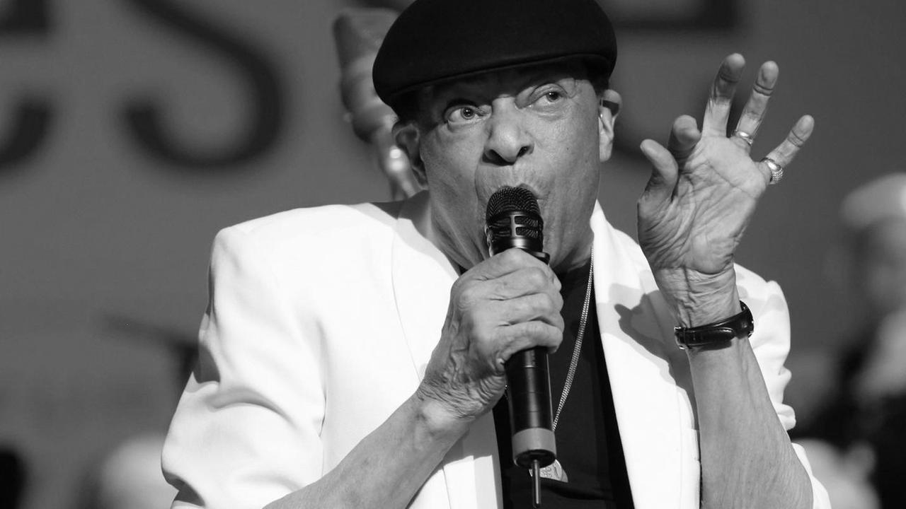 Al Jarreau mit Mikro vor dem Mund auf der Bühne.