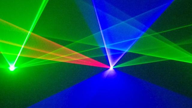 Lasershow, konzipiert von Michael Ramjoué: grüne, blaue und rote Lichtkegel vor schwarzem Hintergrund überschneiden sich