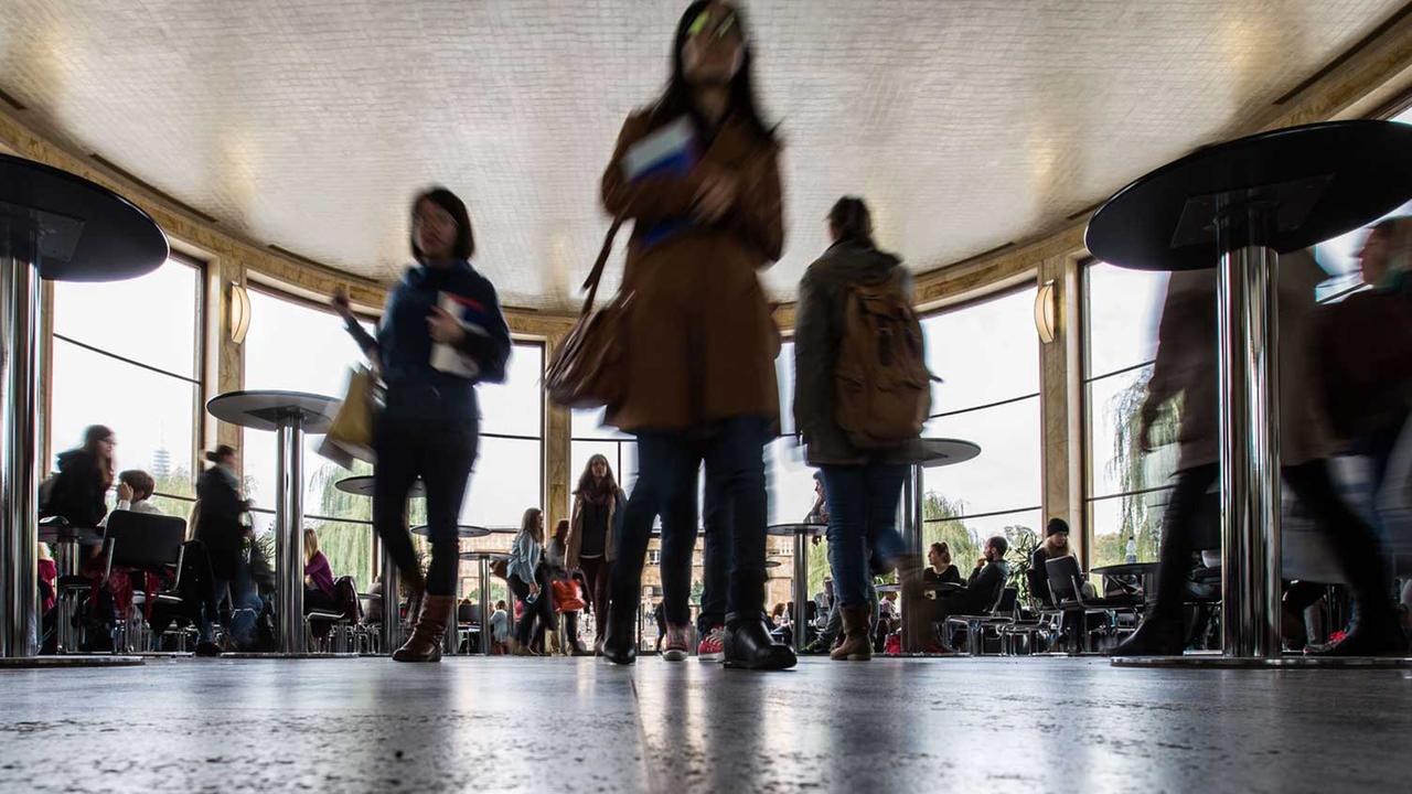 Studenten gehen am 14.10.2014 auf dem Campus Westend der Johann Wolfgang Goethe-Universität in Frankfurt am Main (Hessen) durch die glasumfasste Rotunde, die auch als Cafe dient.