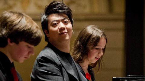 Der chinesische Pianist Lang Lang spielt Klavier mit jungen Leuten