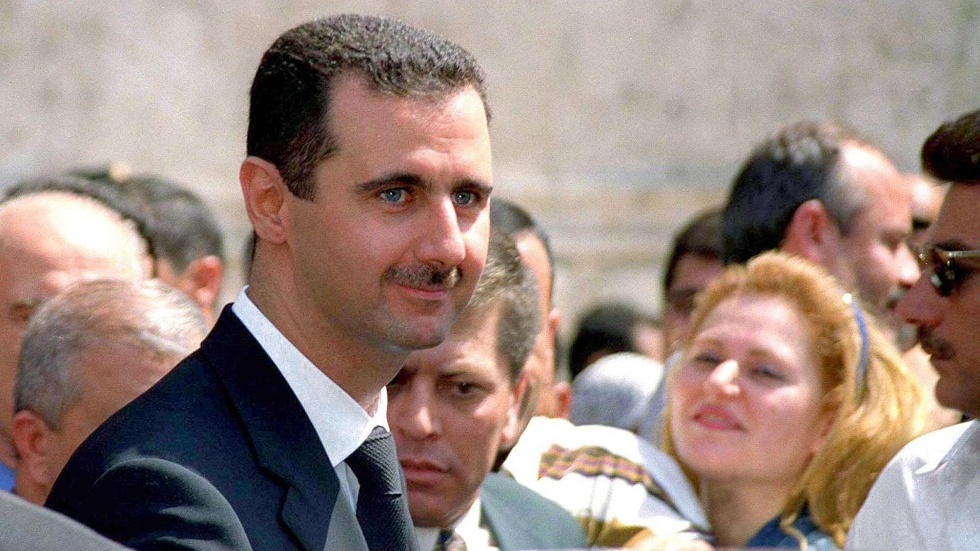 Baschar al-Assad steht in einer Menschenmenge.