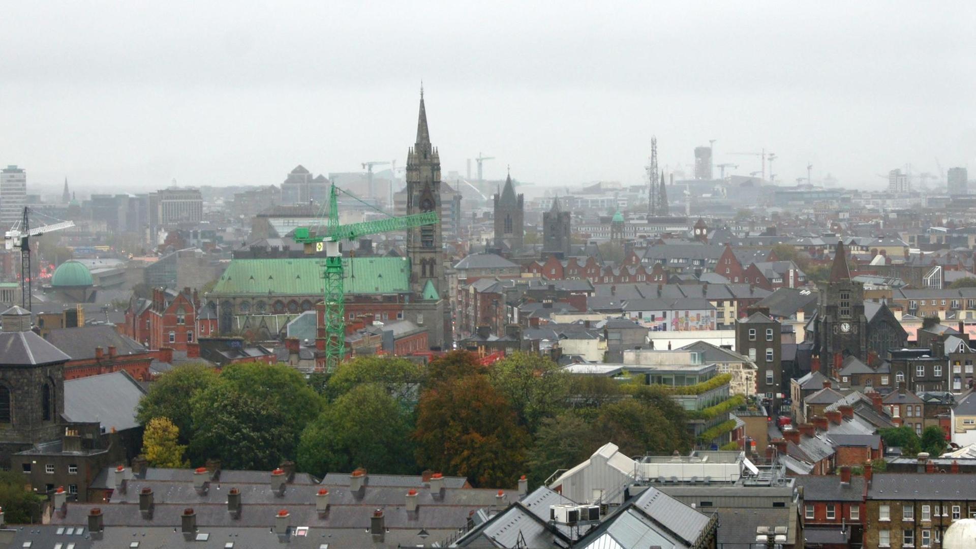 Dublin, Irland. Stadtübersicht bei Regen. Mitte: Katholische Augustinius John's Lane Church und die Türme der mittelalterliche Christ Church Cathedral. Blick vom Dachrestaurant der Guinness-Brauerei.