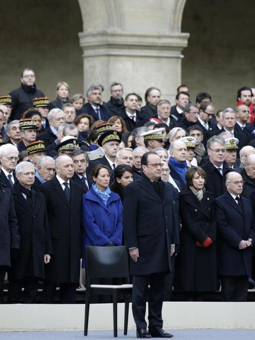 Frankreichs Präsident Hollande steht vor dem Invalidendom. Im Hintergrund sind viele weitere Menschen zu sehen.