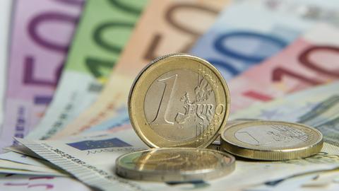 Zahlreiche Euro-Banknoten und Euromünzen