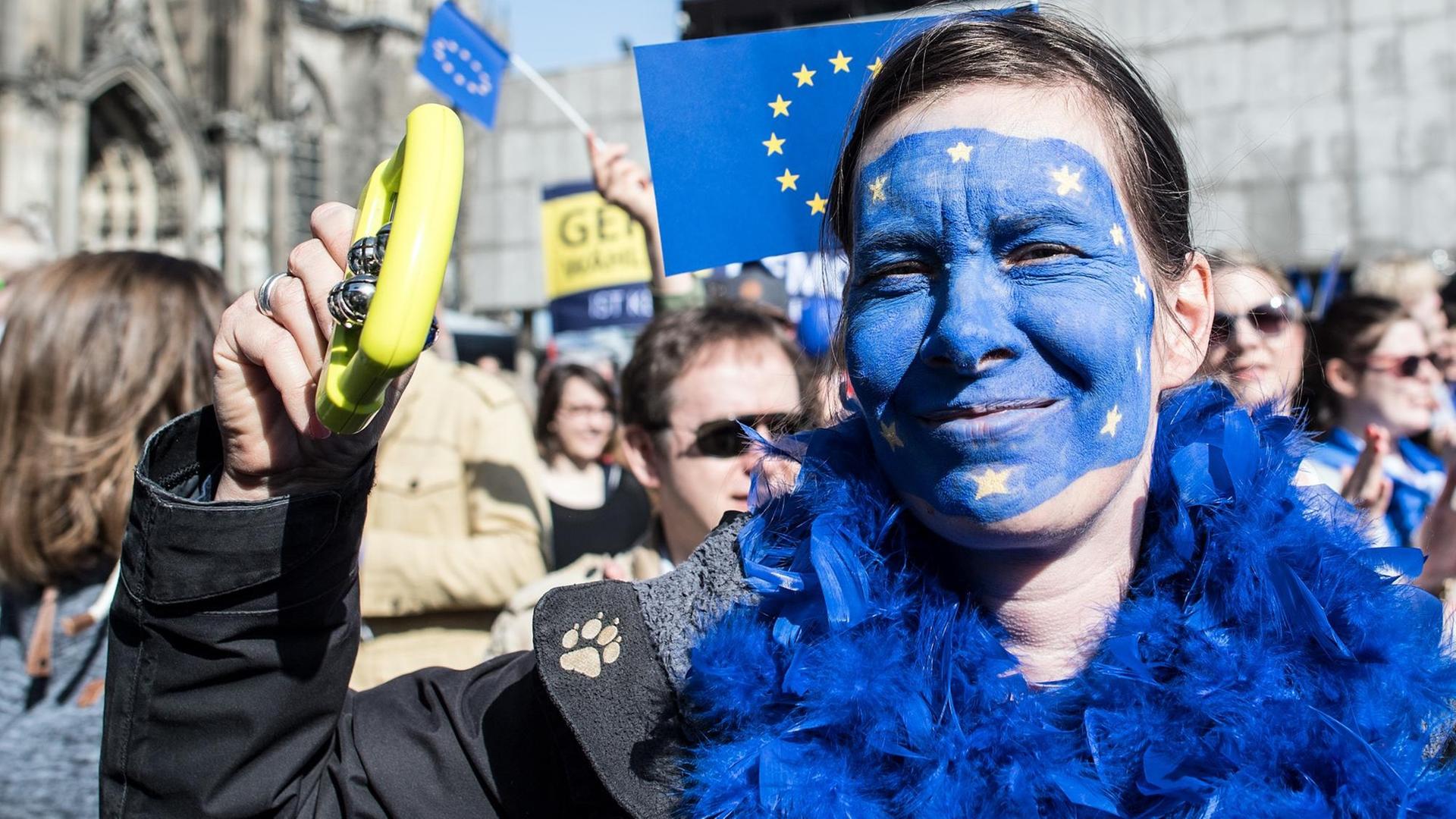 Eine Teilnehmerin der Demo hat sich das Gesicht in den Farben der Europa-Flagge geschminkt