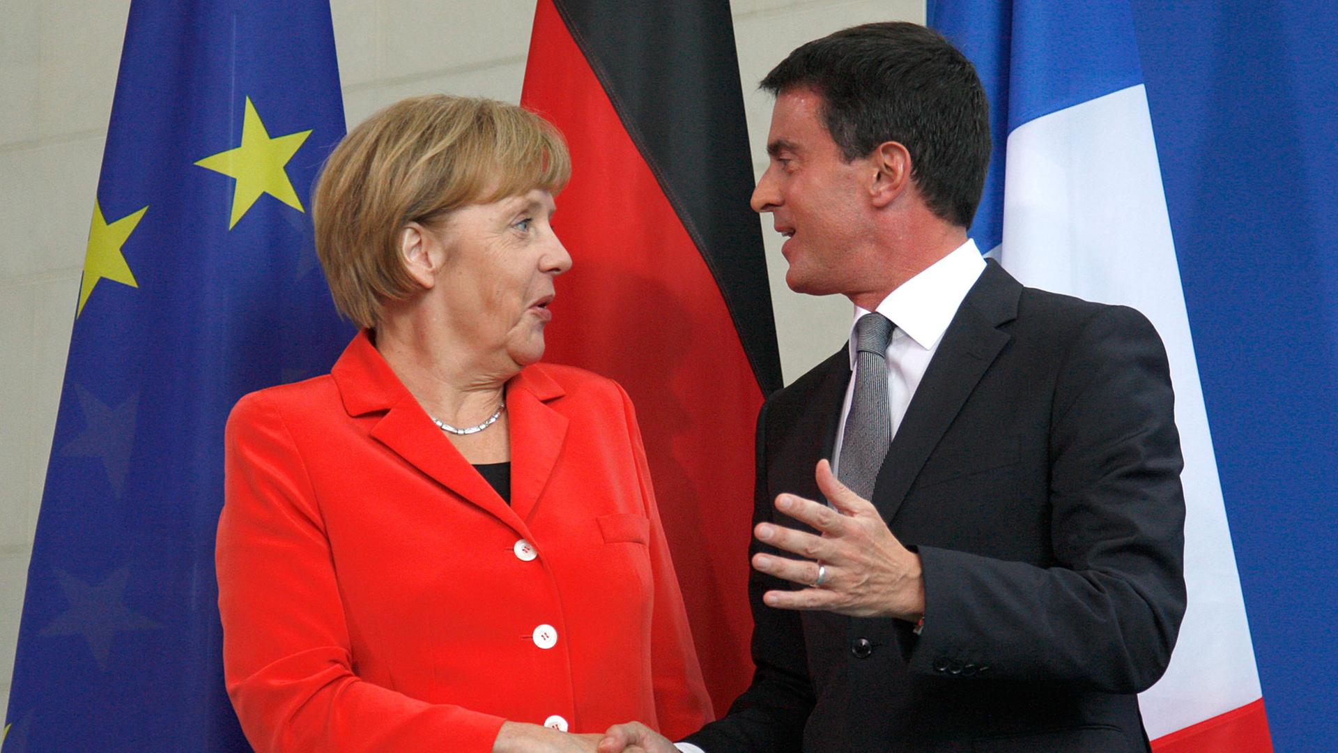 Frankreichs Premierminister Manuel Valls (r.) und Bundeskanzlerin Angela Merkel schütteln die Hände nach einer gemeinsamen Pressekonferenz in Berlin am 22.09.2014.