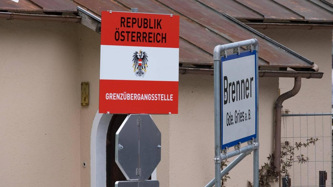 Farbfoto von zwei Schildern vor einer Hauswand, auf einem steht Republik Österreich Grenzübergangsstelle, auf dem anderen Brennerpass