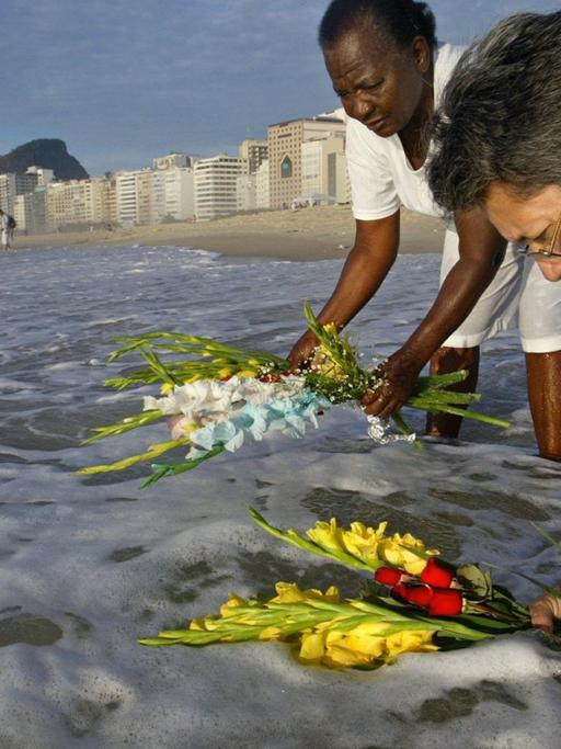 Gläubige opfern Blumen für die Meeresgöttin Iemanjá am Strand von Rio de Janeiro in Brasilien