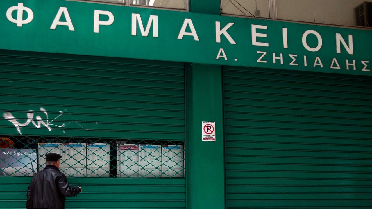 Ein älterer Mann steht am 10. März 2014 vor einer geschlossenen Apotheke in Athen, deren Besitzer gegen die Pläne der Regierung mit Streik protestiert, verschreibungsfreie Medikamente in Supermärkten zu verkaufen.