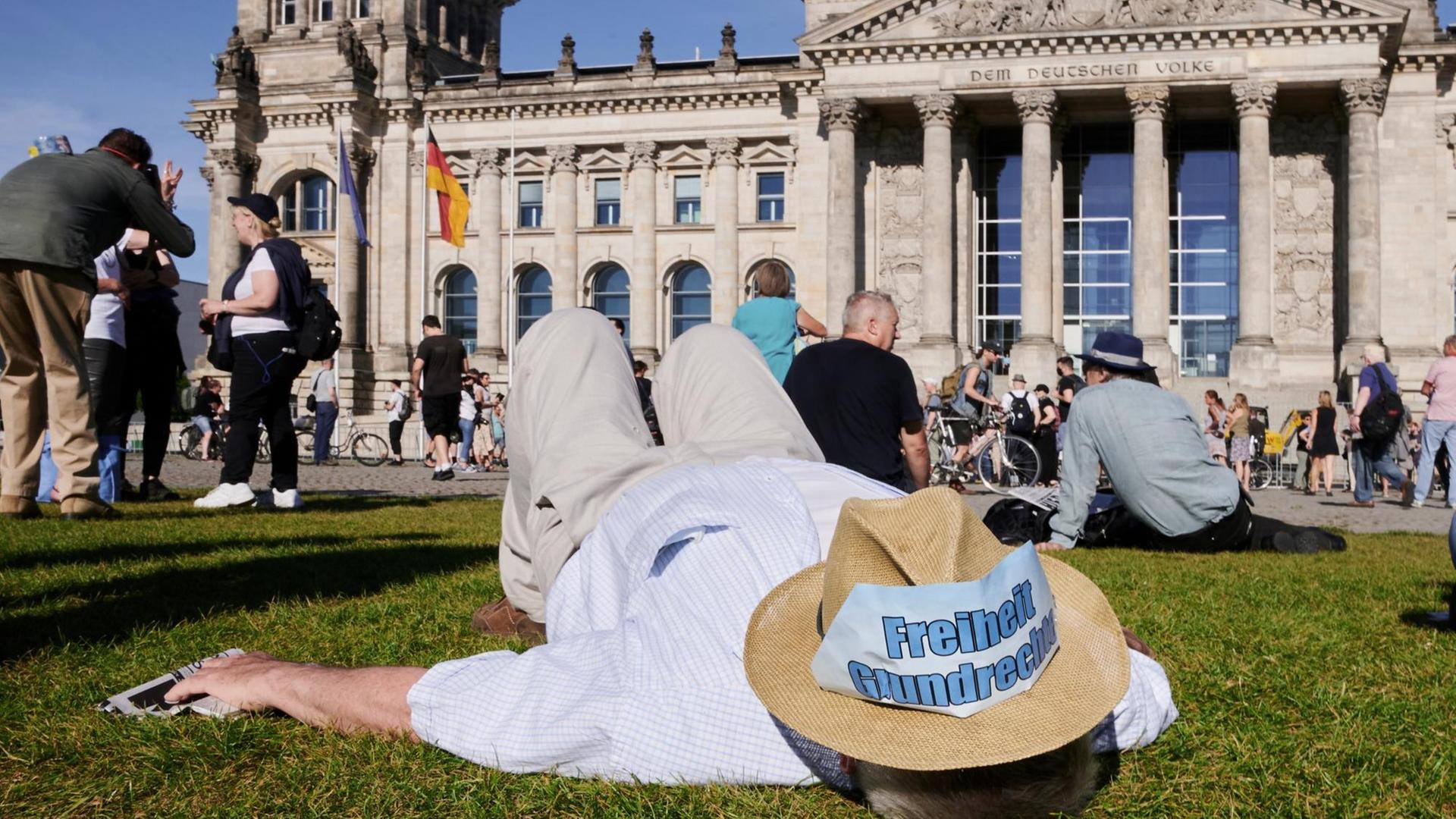 "Freiheit – Grundrechte" steht auf einem Hut, den ein Demonstrant auf der Wiese liegend trägt. Vor dem Reichstag fand die Kundgebung "Demokratischer Widerstand, für die Wiederherstellung verfassungsgemäßer Demokratie" statt.