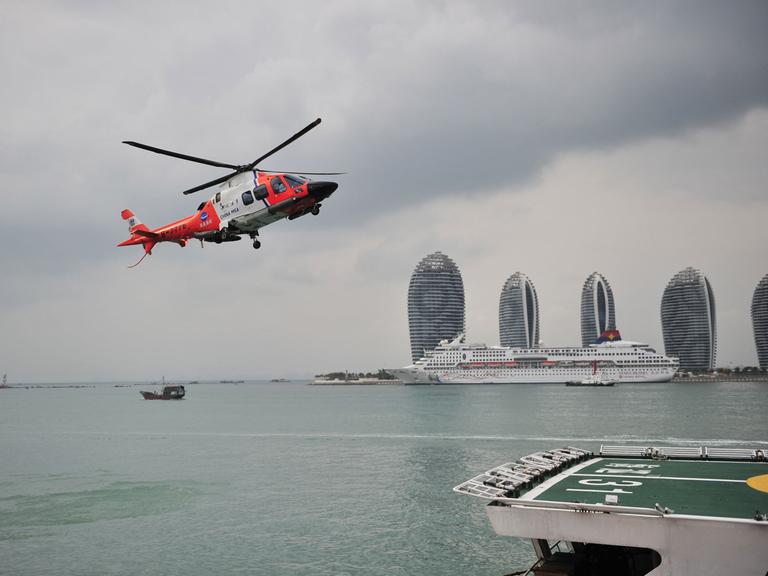 Ein Helikopter landet auf dem Deck eines chinesischen Marineschiffes, das mit der Suche nach der verschollenen Boeing 777-200 im südchinesischen Meer beauftragt ist.