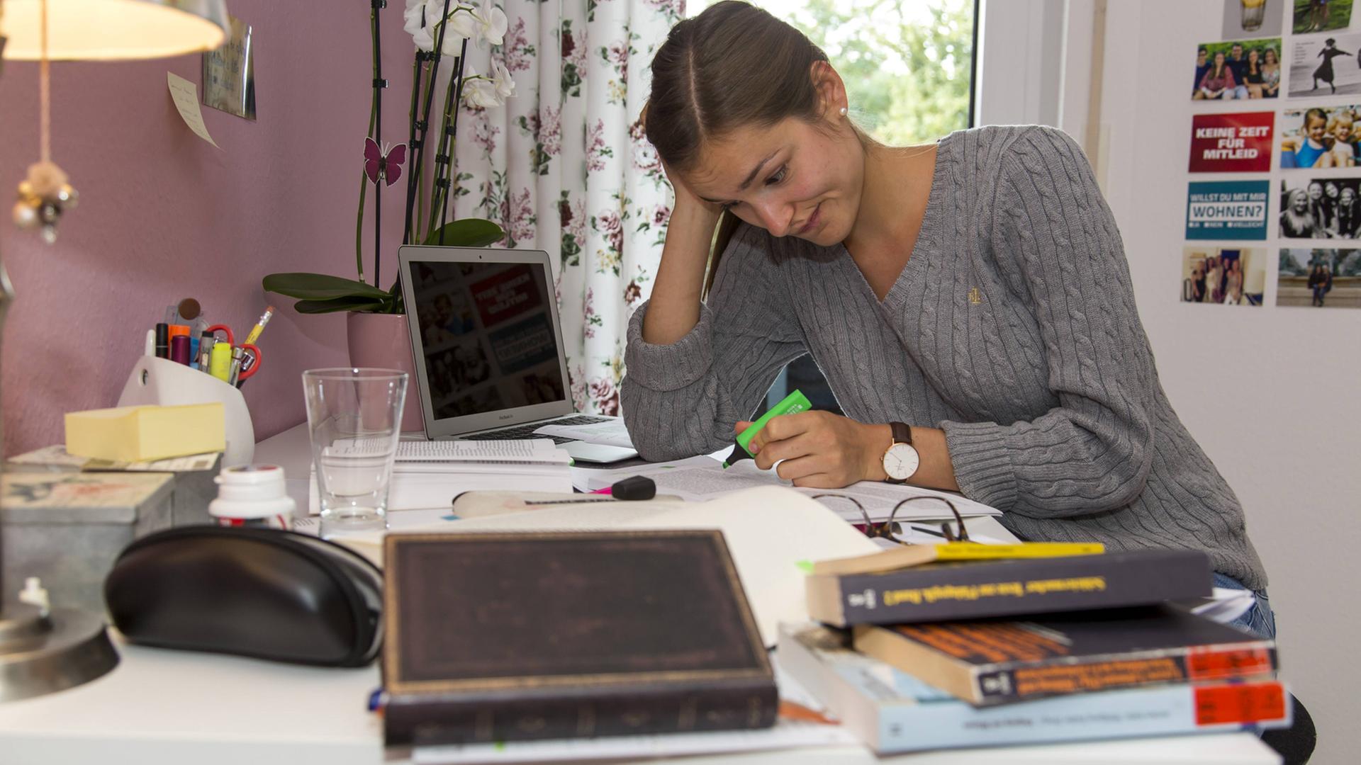Eine Studentin lernt in ihrer Wohnung für eine Prüfung.