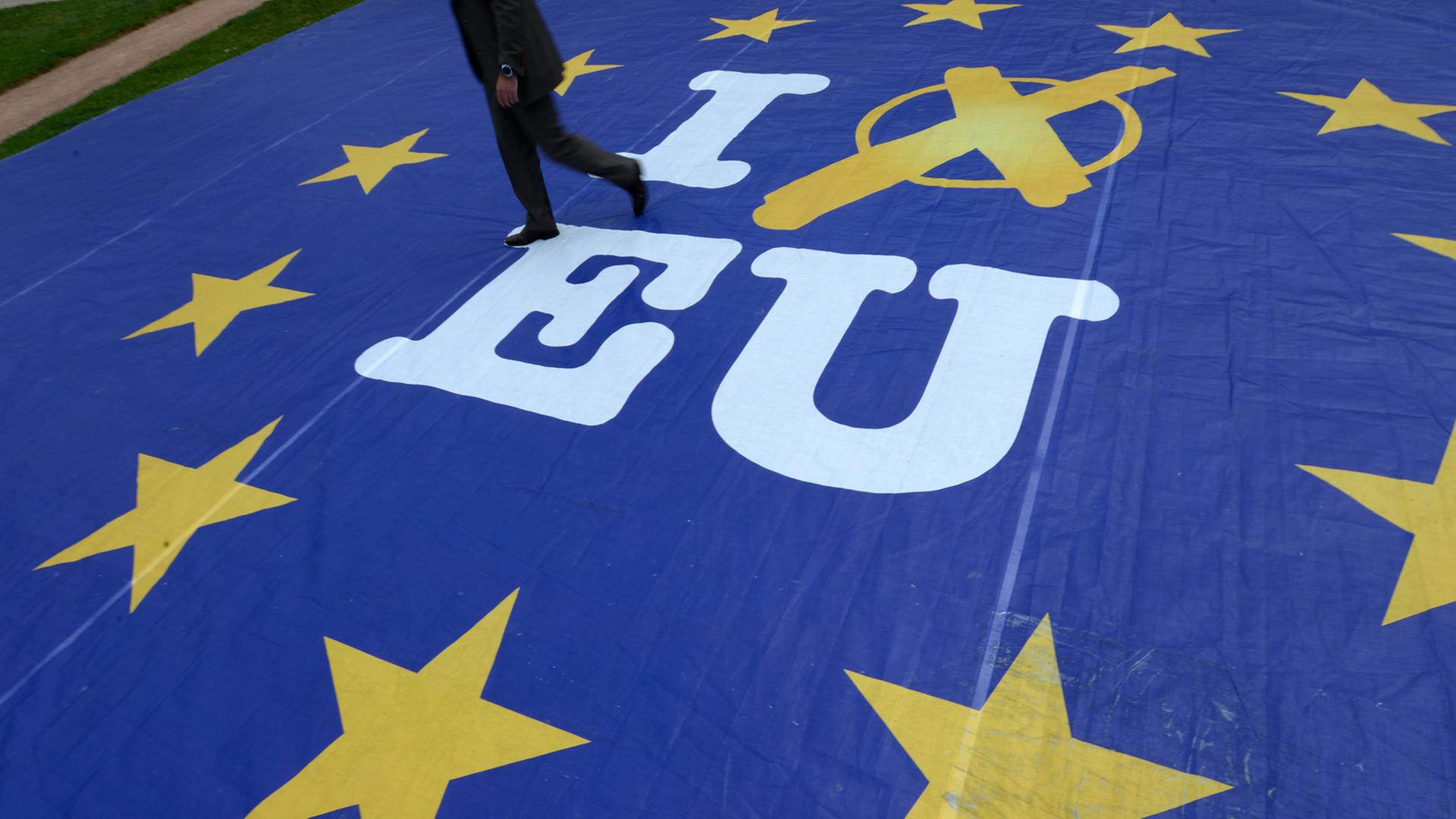 Ein Mann geht am 21.05.2014 in Wiesbaden (Hessen) über ein Aktionsbanner mit der Aufschrift "I vote EU".