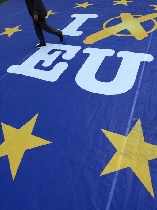 Ein Mann geht am 21.05.2014 in Wiesbaden (Hessen) über ein Aktionsbanner mit der Aufschrift "I vote EU".