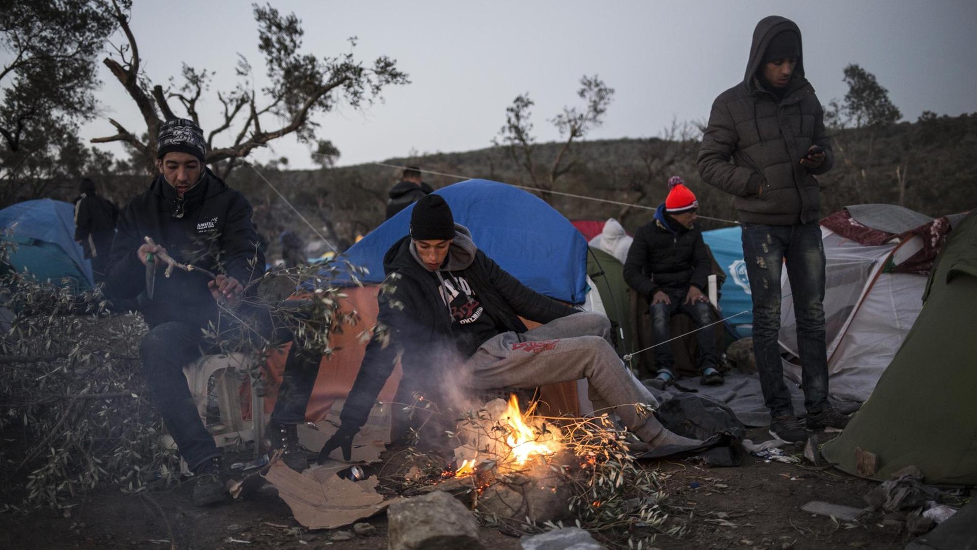Junge Flüchtlinge wärmen sich an einem Lagerfeuer auf der Insel Lesbos