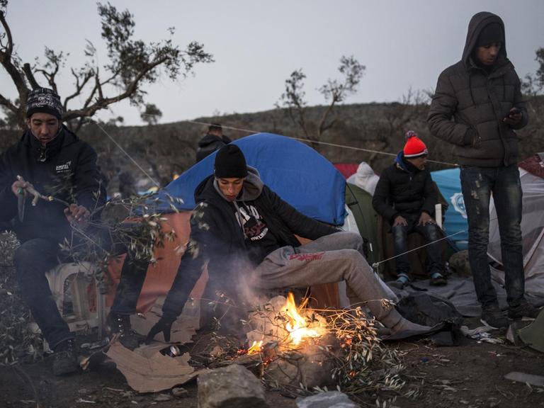Junge Flüchtlinge wärmen sich an einem Lagerfeuer auf der Insel Lesbos
