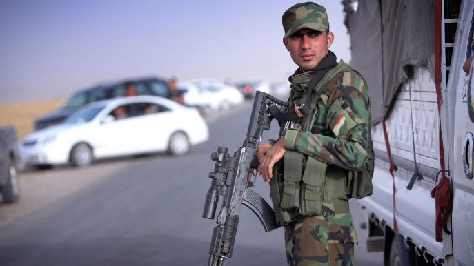 Ein bewaffneter irakisch-kurdischer Soldat bewacht eine Straße in der nord-irakischen Provinz Ninive, wo sich fliehende Familien sammeln. 