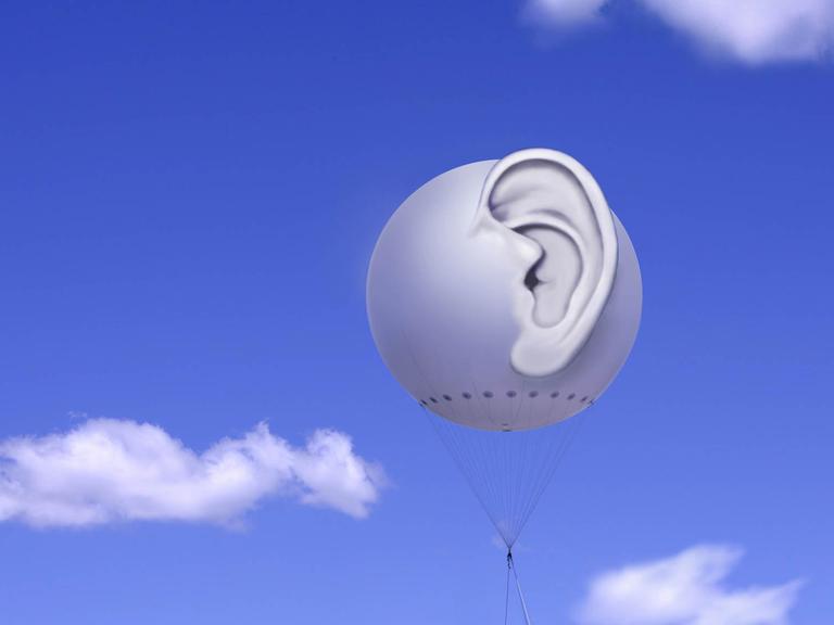 Fesselballon mit dreidimensionalem menschlichem Ohr vor blauem Himmel mit weißen Wolken (Symbolbild)