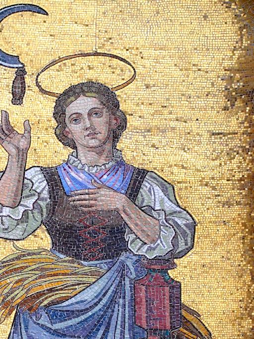 Mosaikbild der Heiligen Notburga mit einer Sichel an der Wallfahrtskirche St. Notburga in Eben am Achensee in Tirol.