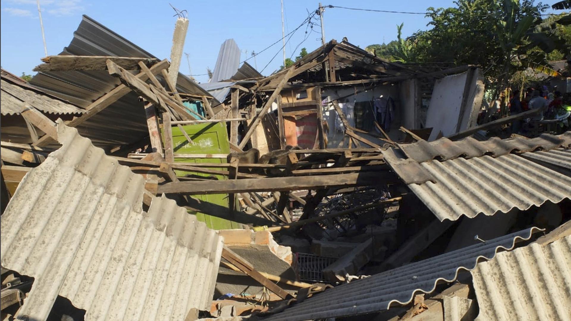 Trümmer von eingestürzten Häusern liegen auf der Erde. 