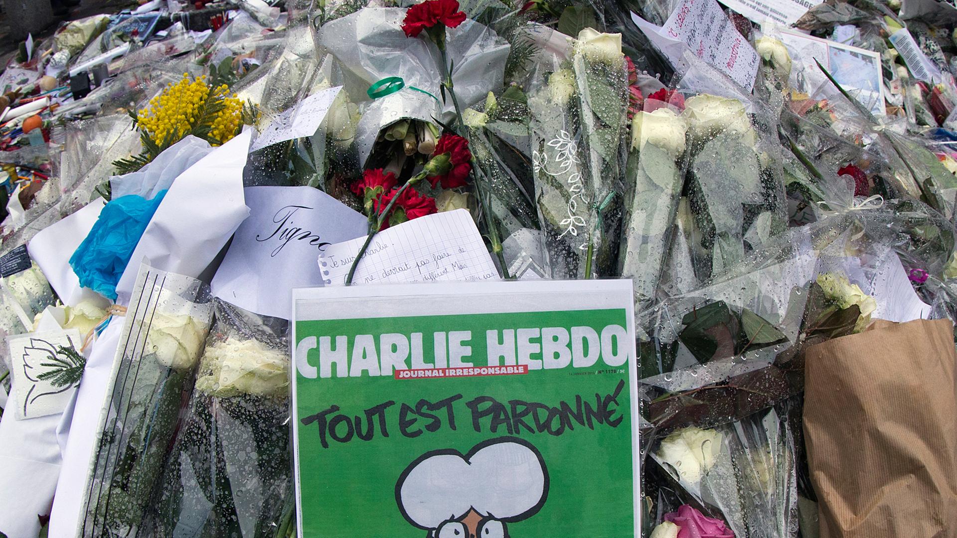 Blumen und die aktuelle "Charlie Hebdo"-Ausgabe vor der Redaktion des Satiremagazins Blumen und die aktuelle "Charlie Hebdo"-Ausgabe vor der Redaktion des Satiremagazins