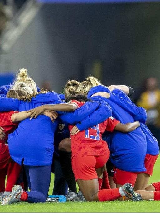 Die Spielerinnen der amerikanische Fußballnationalmannschaft formen einen Mannschaftskreis im Stadion im französischen Reims.