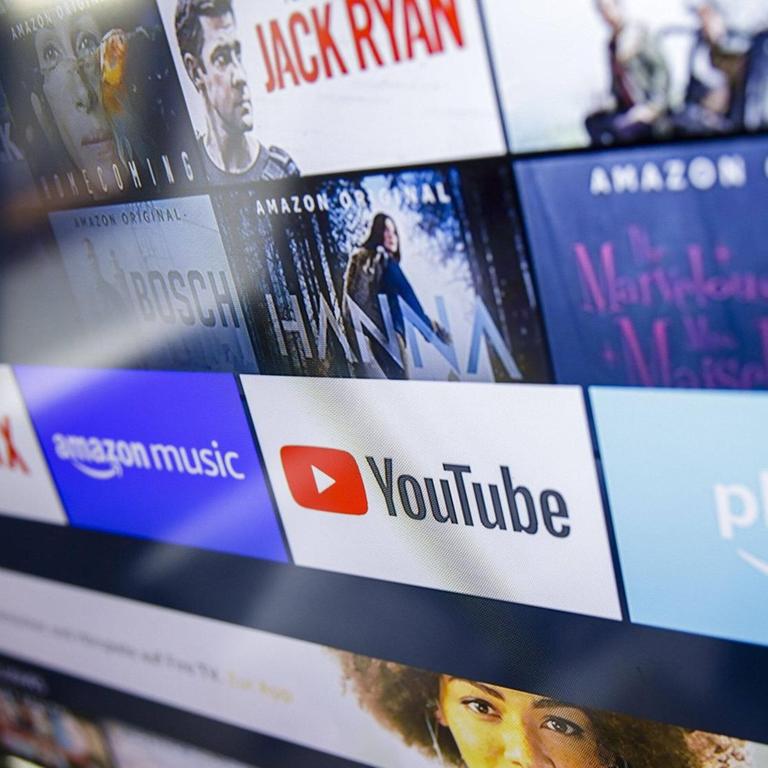 Die Logos der Streaming Dienste Amazon Prime Video, Netflix, amazon music und youtube sind auf einem Fernseher zu sehen.