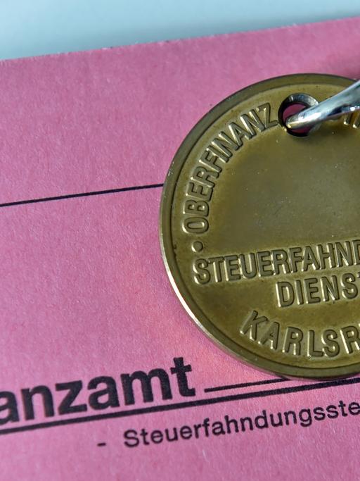 Dienstmarke eines Steuerfahnders auf einer Akte des Finanzamts