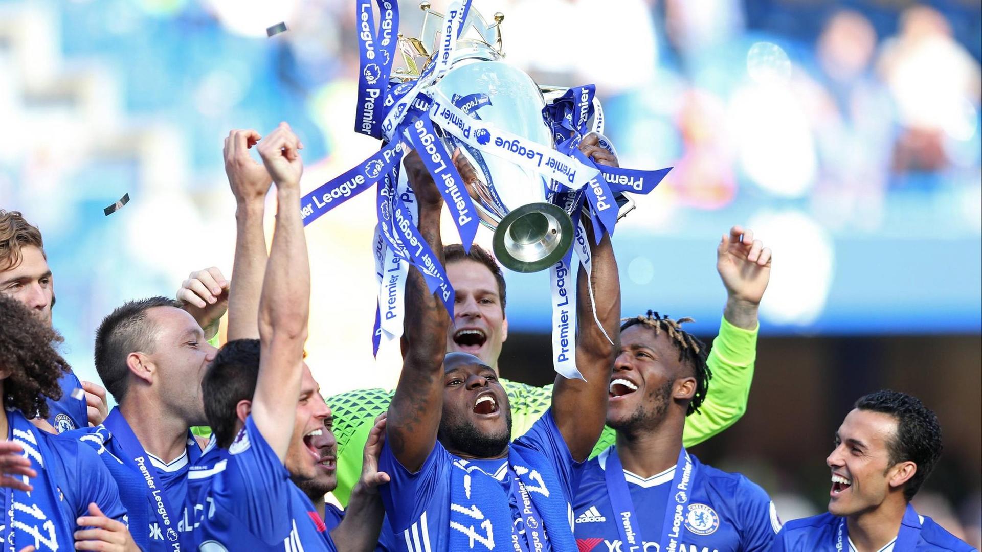 Spieler des FC Chelsea feiern den Gewinn der englischen Fußball-Meisterschaft. Sie halten den Pokal in die Höhe und jubeln.