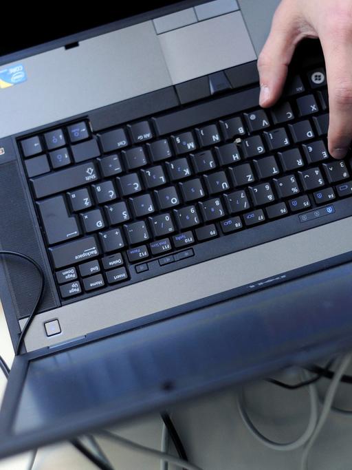 Eine Person bedient einen Laptop mit einer Mouse.
