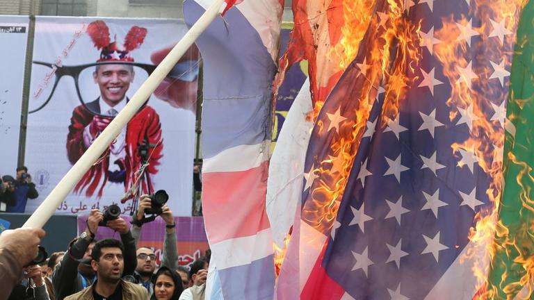 Iraner brennen in Teheran vor der ehemaligen US-Botschaft die Flagge der USA ab.