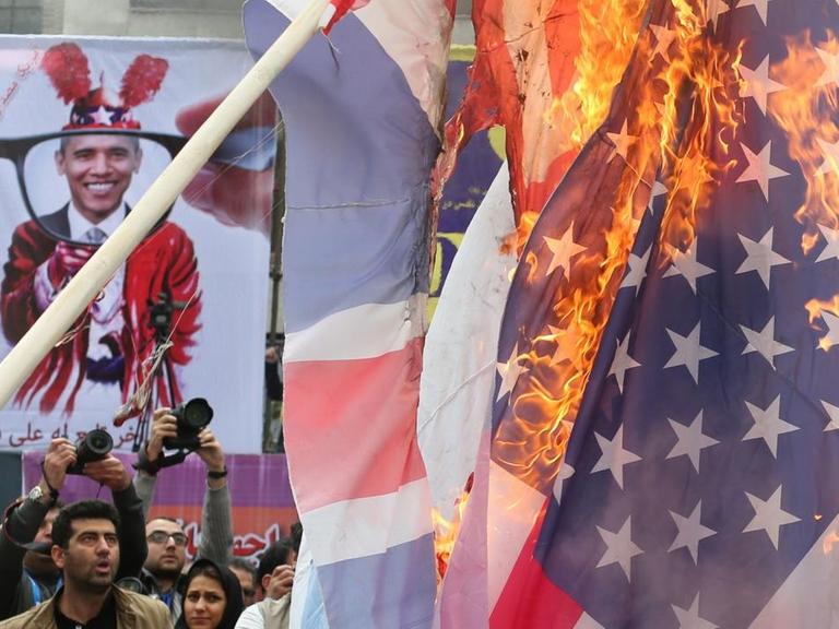 Iraner brennen in Teheran vor der ehemaligen US-Botschaft die Flagge der USA ab.
