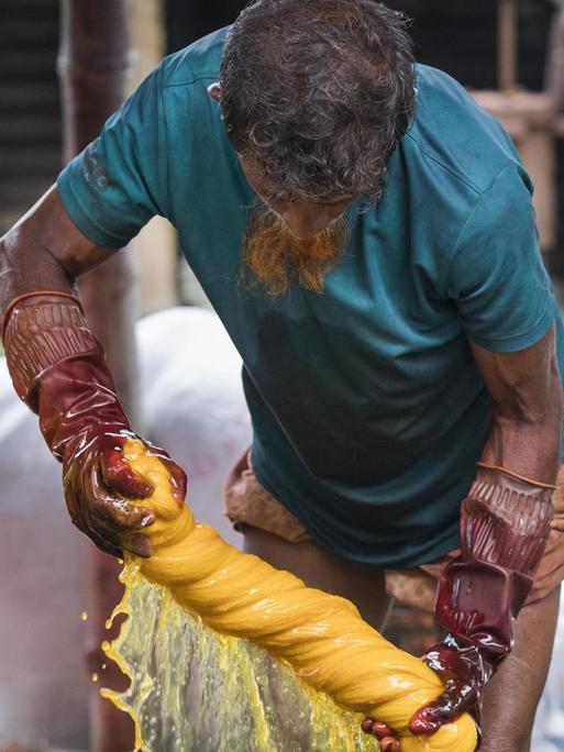 Ein Arbeiter in Bangladesh färbt Kleidung