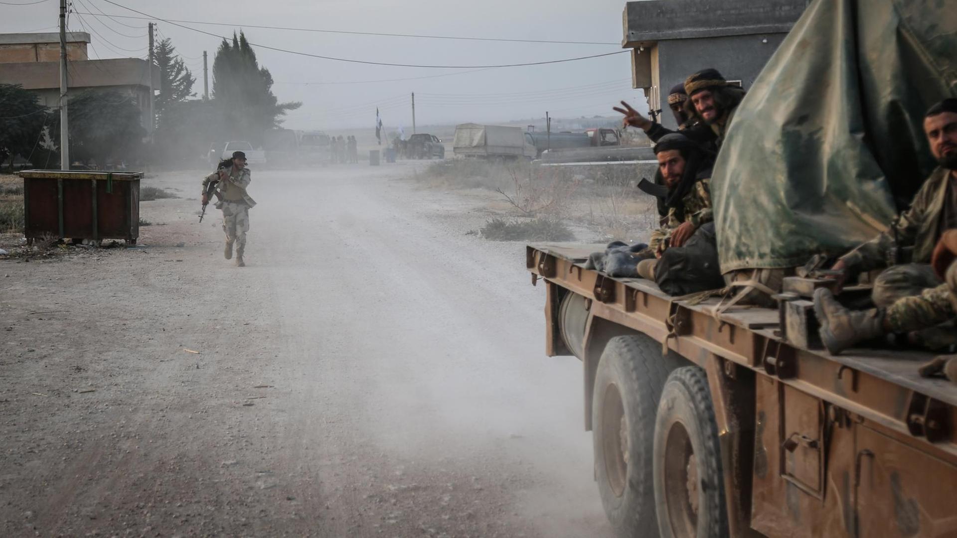 Syrien, Tell Abiad: Soldaten der türkisch unterstützten syrischen Nationalarmee gestikulieren nach Zusammenstößen mit Kurdischen Kämpfern. In ihrem erbitterten Kampf gegen türkischen Truppen erhalten die Kurdenmilizen in Nordsyrien Unterstützung der Regierung von Präsident Baschar al-Assad.
