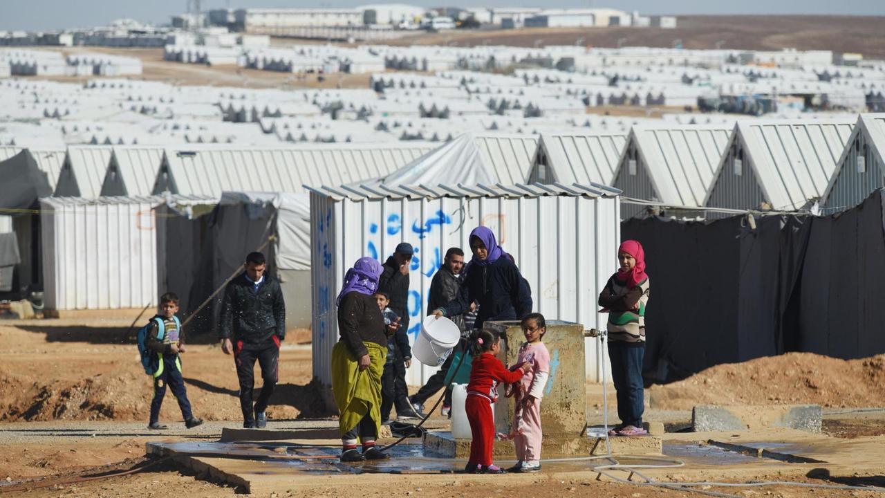 Frauen und Kinder vor den Hütten des UNHCR-Flüchtlingslagers in Azraq im jordanischen Al-Azraq.