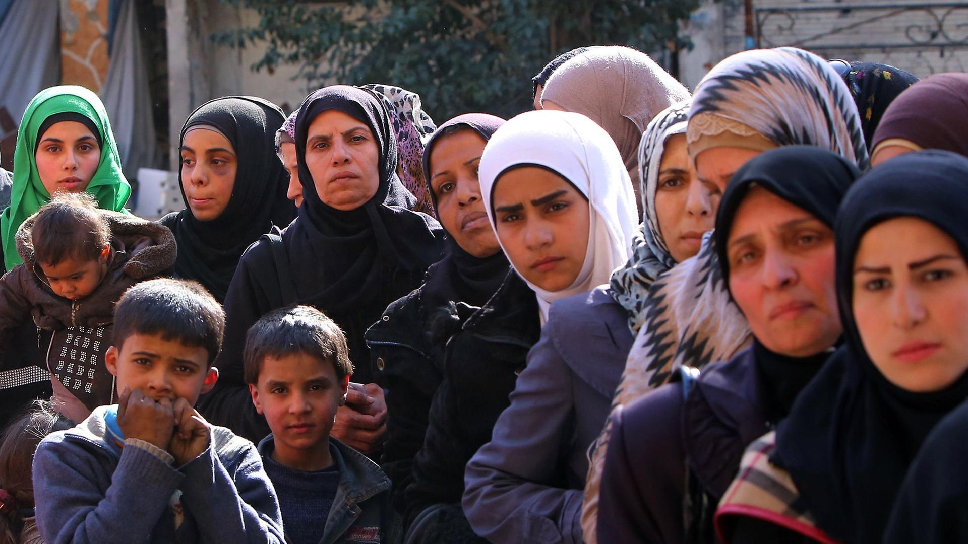 Palästinenser warten im Stadtteil Jarmuk auf Essen von der UNO