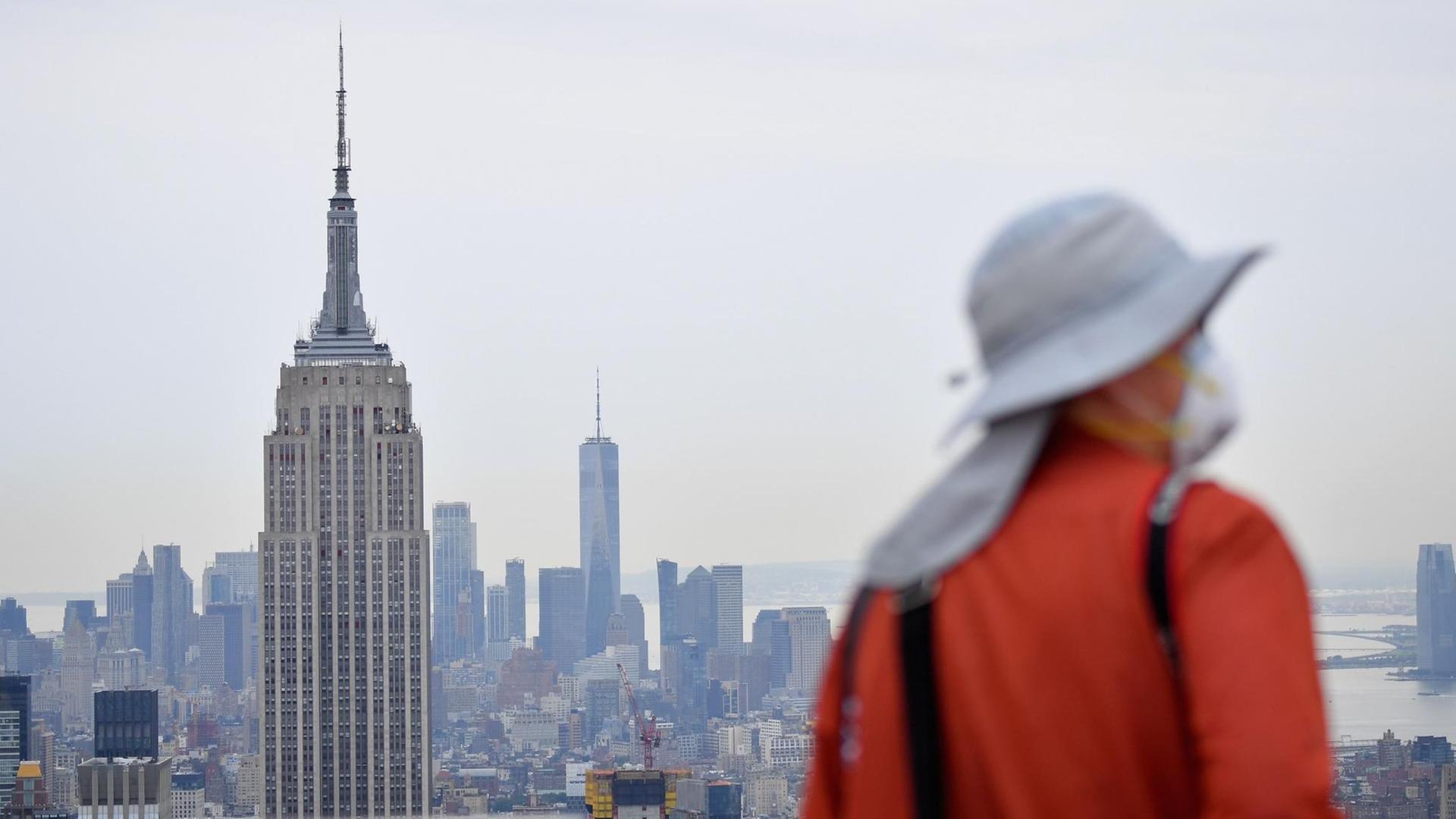 Ein Fotograf mit Maske steht auf der Ausblicks-Plattform des New Yorker Rockefeller Center