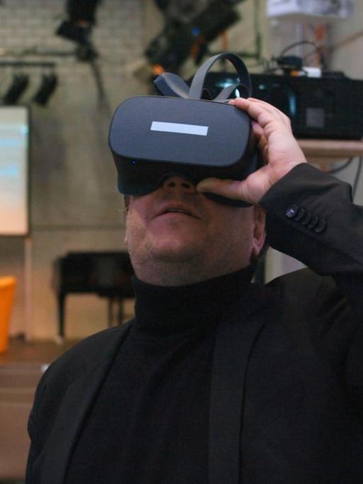 Ein Mann mit VR-Brille schaut sich in einem Theater um.